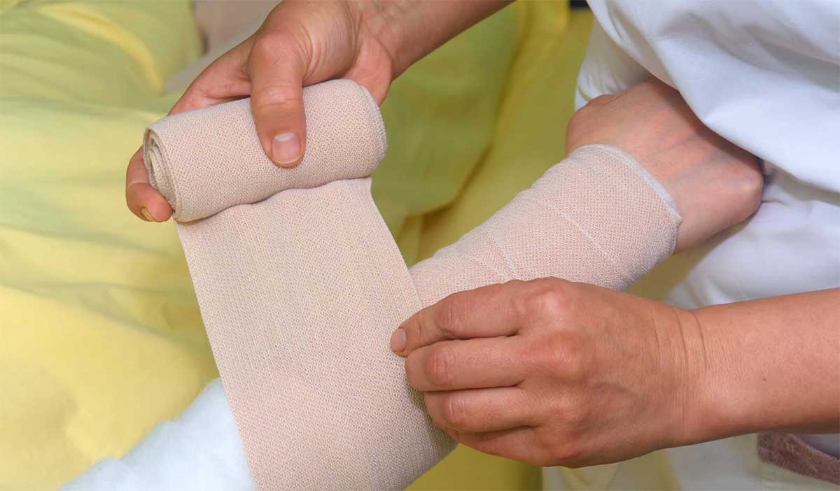 A-therapist-applying-combine-decongestive-therapy-via-bandages-to-a-lymphoedema-arm