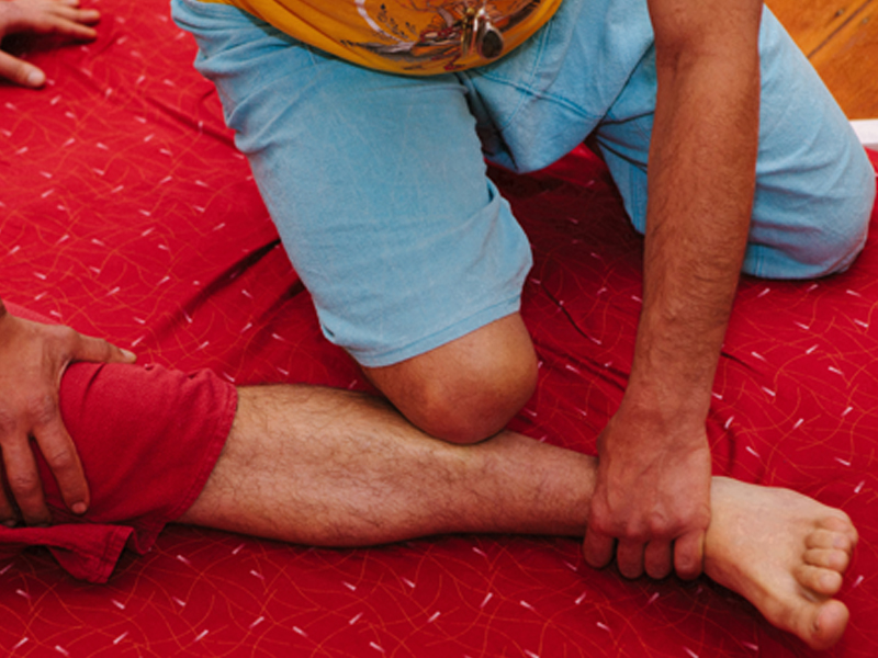 Giovanni doing Thai Massage with the knee on a shin muscle